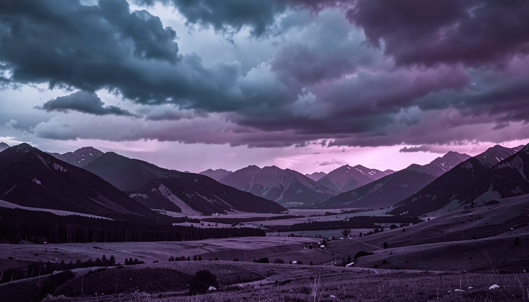 Weite Berglandschaft der Nordkette unter einem dramatischen Himmel mit tiefhängenden Wolken, in kühlen Blau- und Grautönen gehalten.
